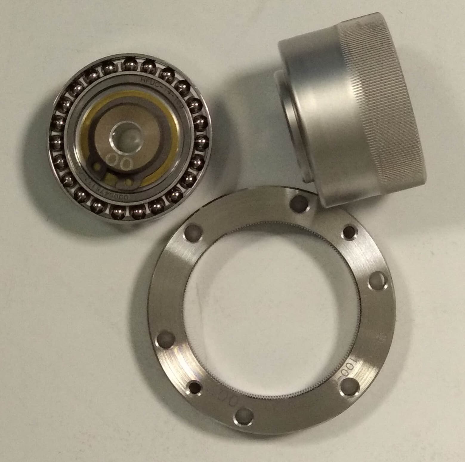 Parts of a strain wave gear: wave generator bearing, flexspline cup and circular spline ring